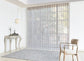 Luxx Shades Leaf vanes on a wide window in a bright living room