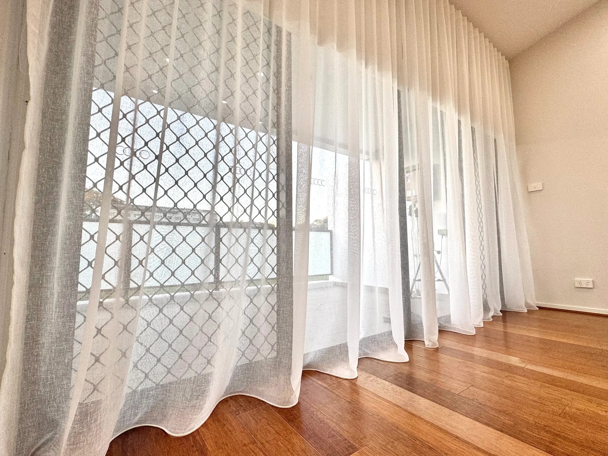 Luxx Shades installed on tall windows with timber floors in a Sydney home